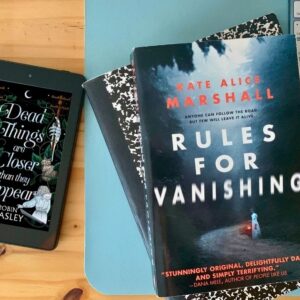 Paperback of Rules for Vanishing by Kate Alice Marshall beside an ereader showing Dead Things Are Closer Than They Appear by Robin Wasley.