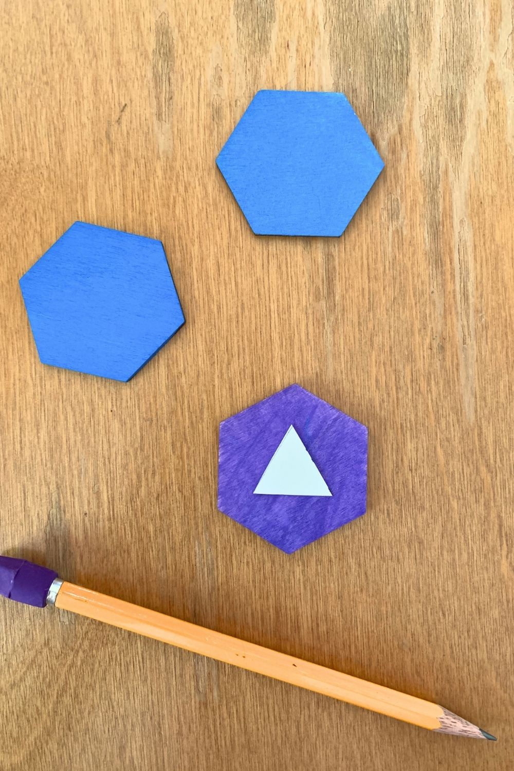 A white paper triangle in the center of a purple wood hexagon.