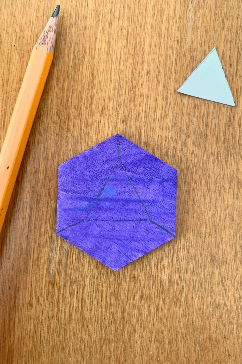 A purple hexagon with a triangle drawn in the center and 3 lines extending to corners.