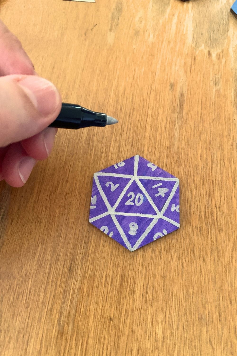 Drawing numbers in each triangle with a silver marker.