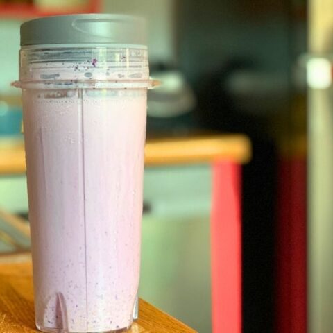 A pale purple blueberry pie smoothie in a blender cup.