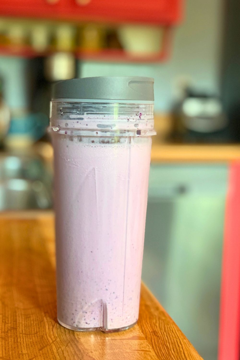 A pale purple blueberry pie smoothie in a blender cup.