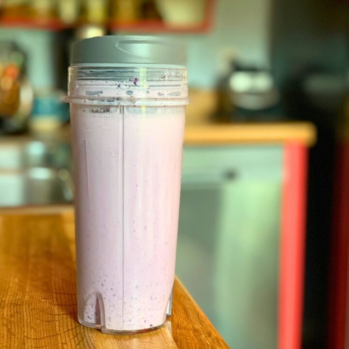 A pale purple blueberry pie smoothie in a blender cup.