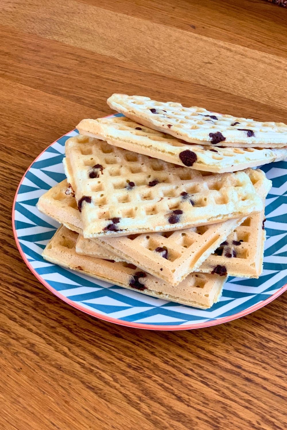 A stack of chocolate orange waffles on a plate, light golden with chocolate chips.