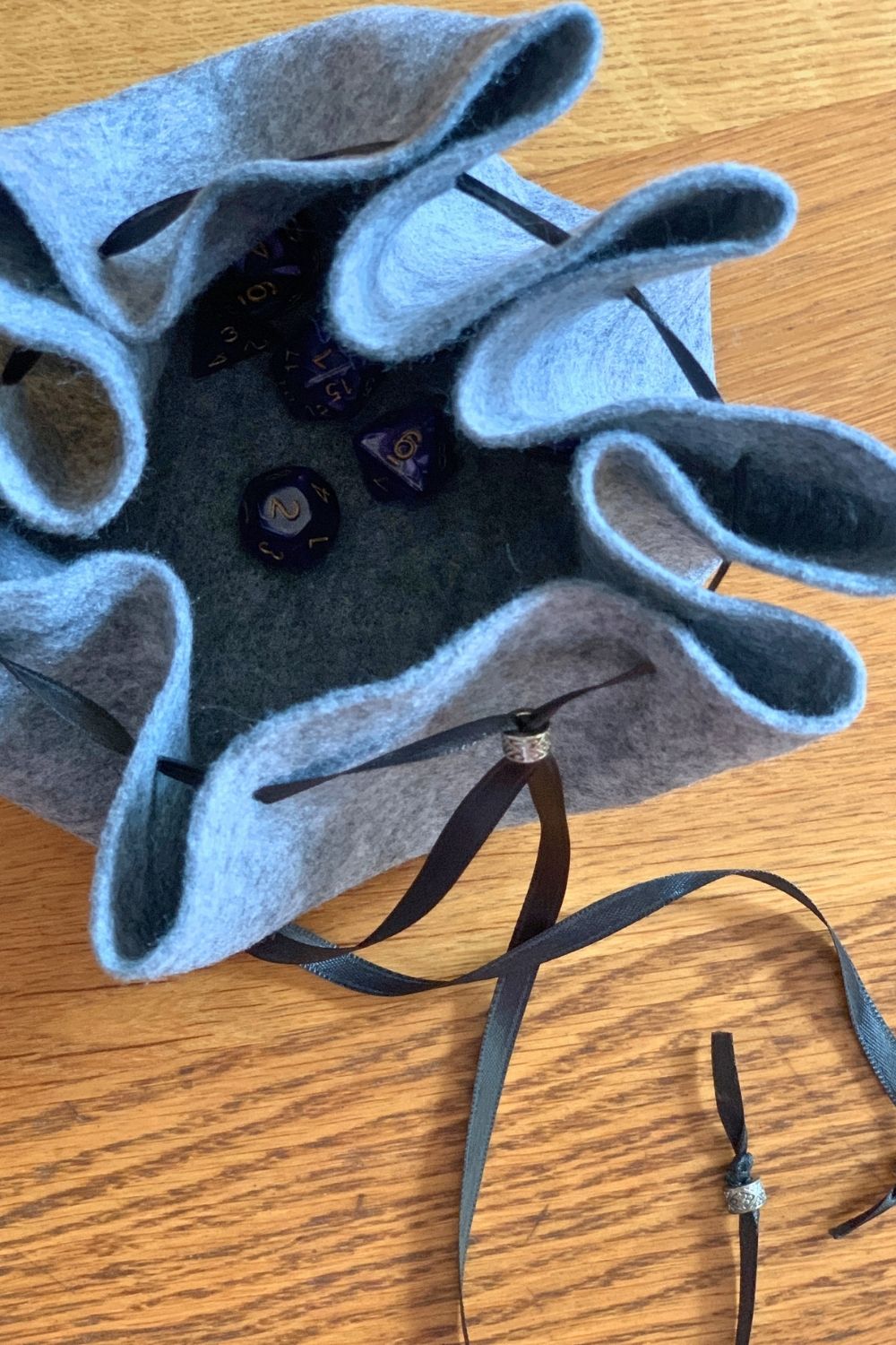 Dice inside a drawstring felt bag.