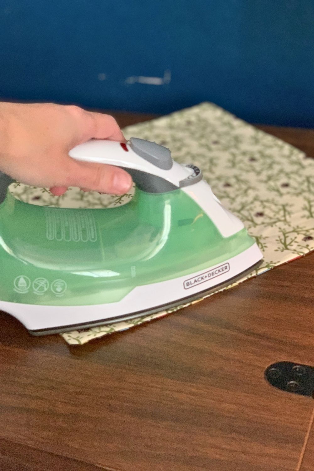 Ironing the hemmed fabric to flatten the edges.