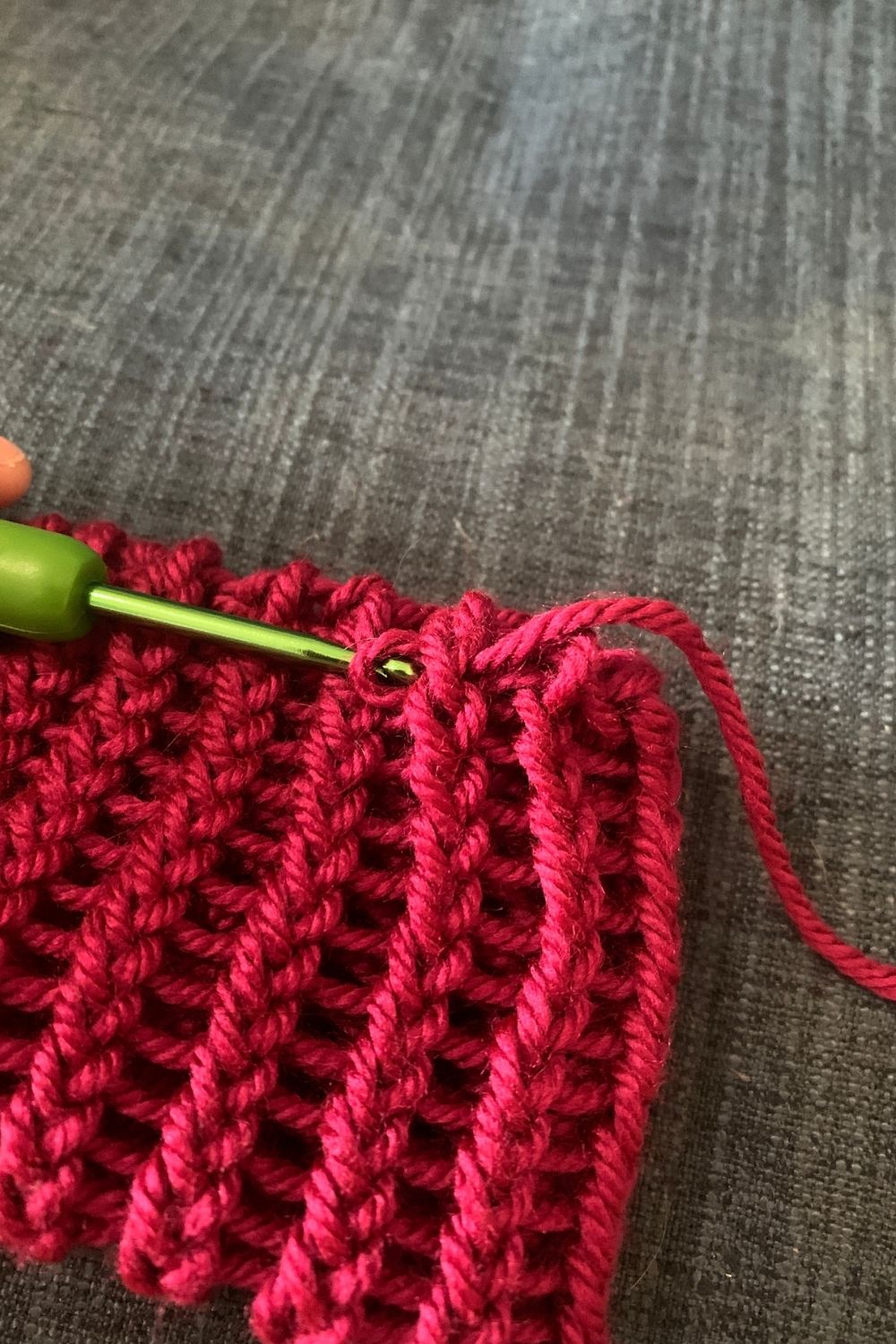 Using a crochet hook to weave in the yarn tails.