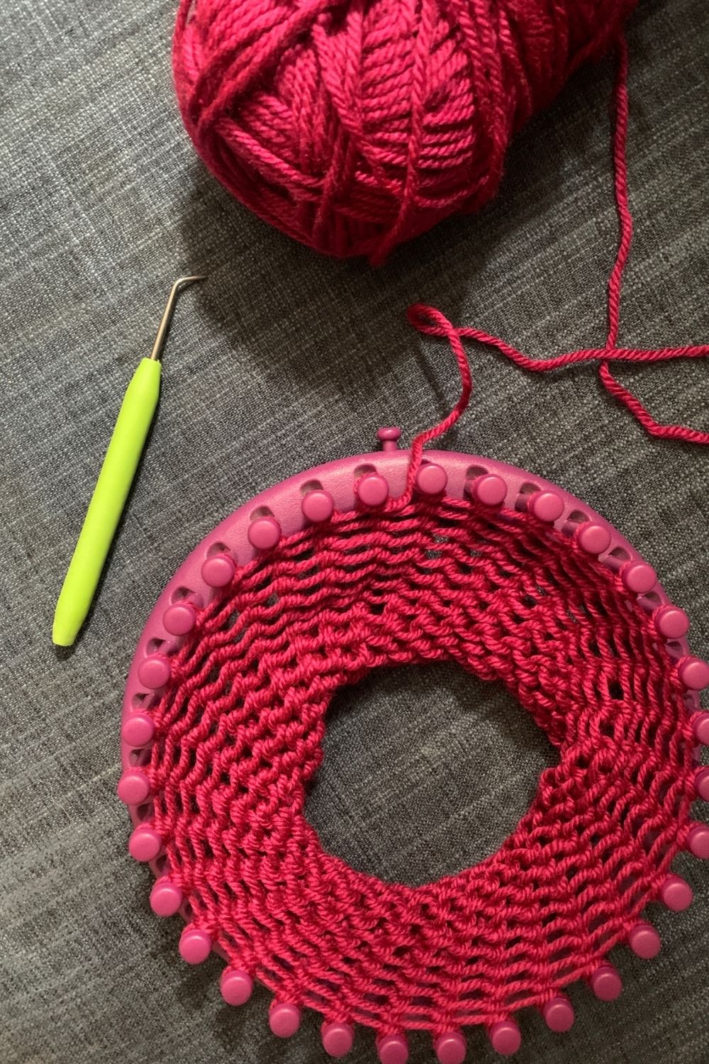 A knitting loom with several inches of knitted yarn in the center.