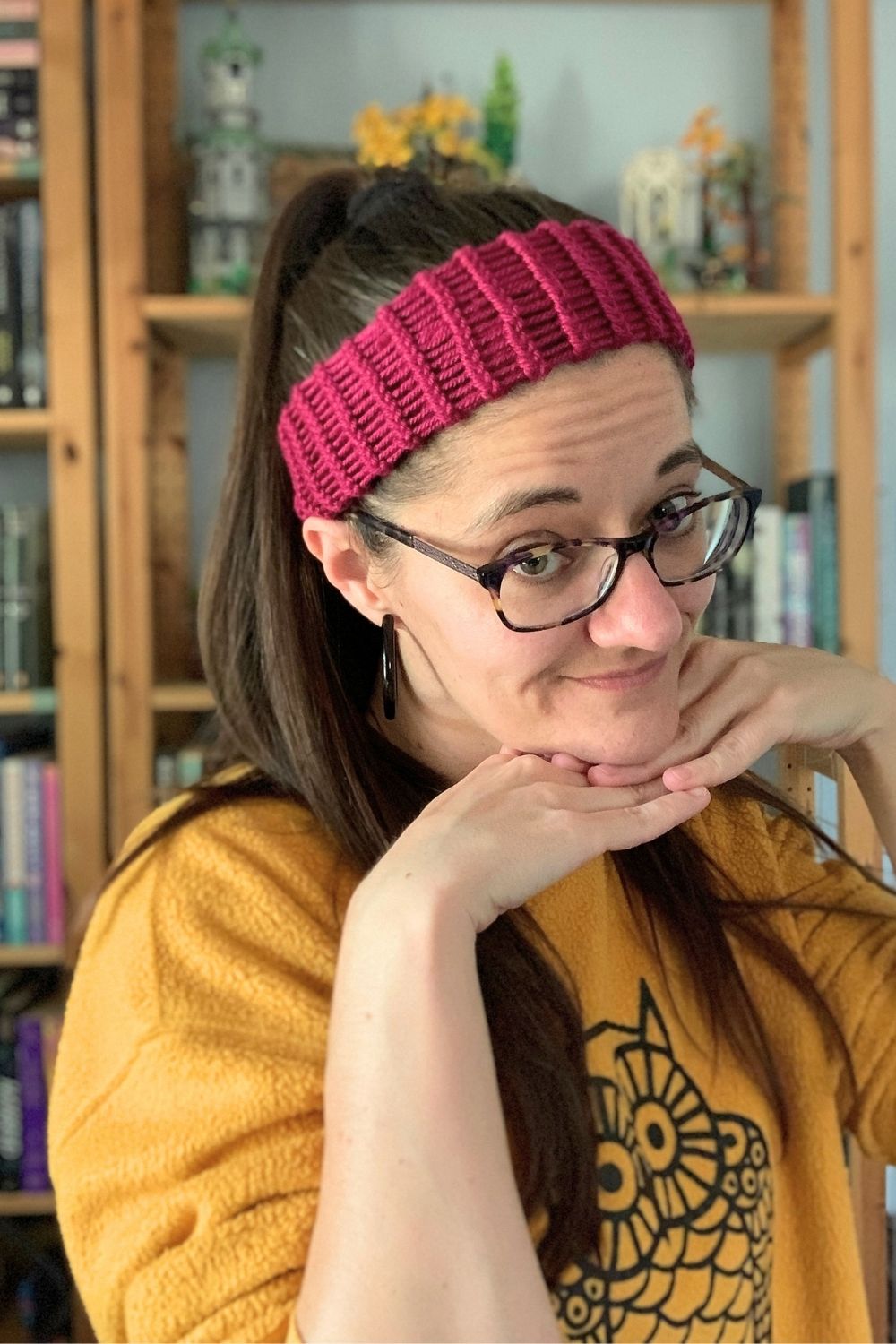 A woman showing off a finished loom-knit headband.