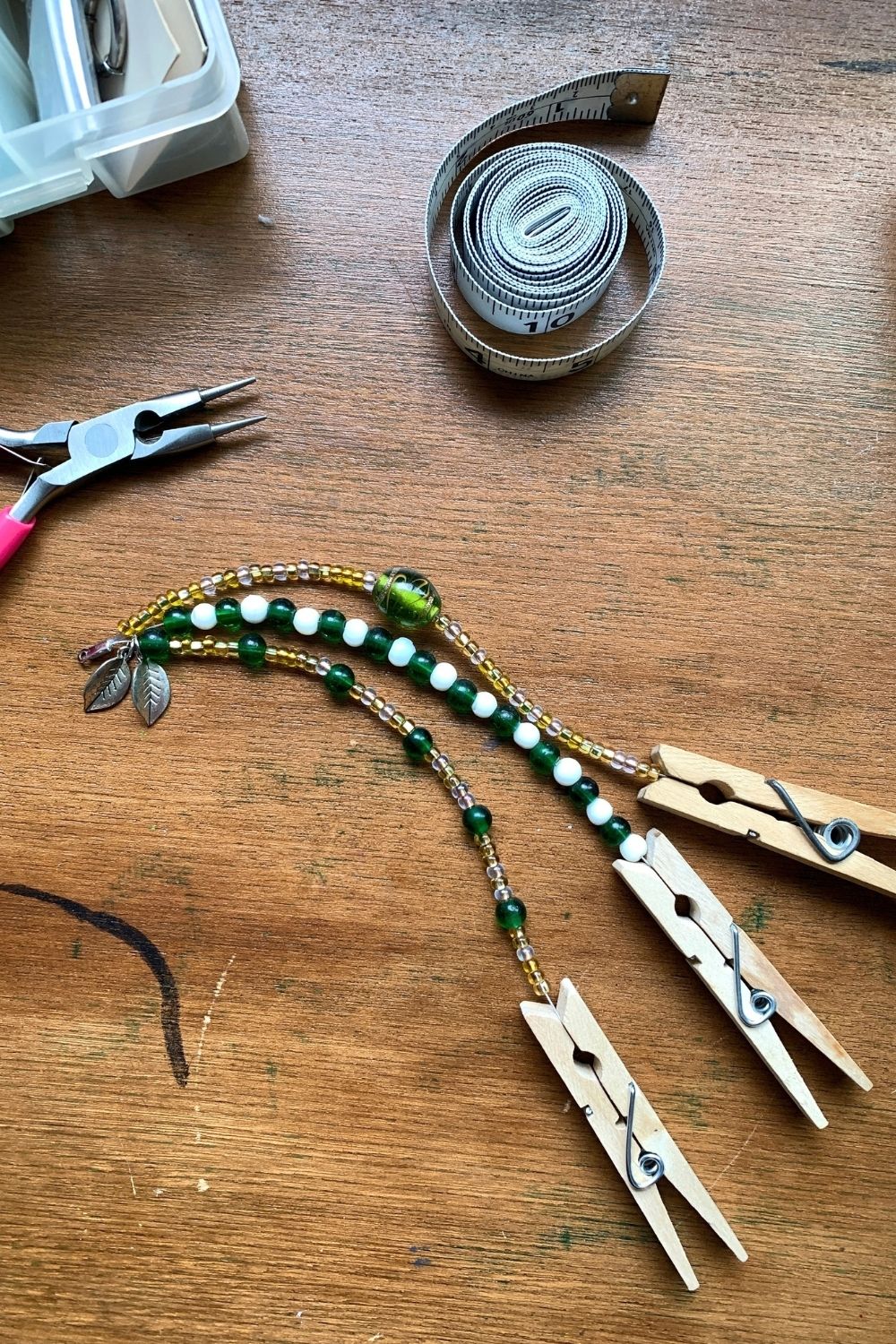 A bracelet with 3 strands on green, gold, and white glass beads in different patterns.