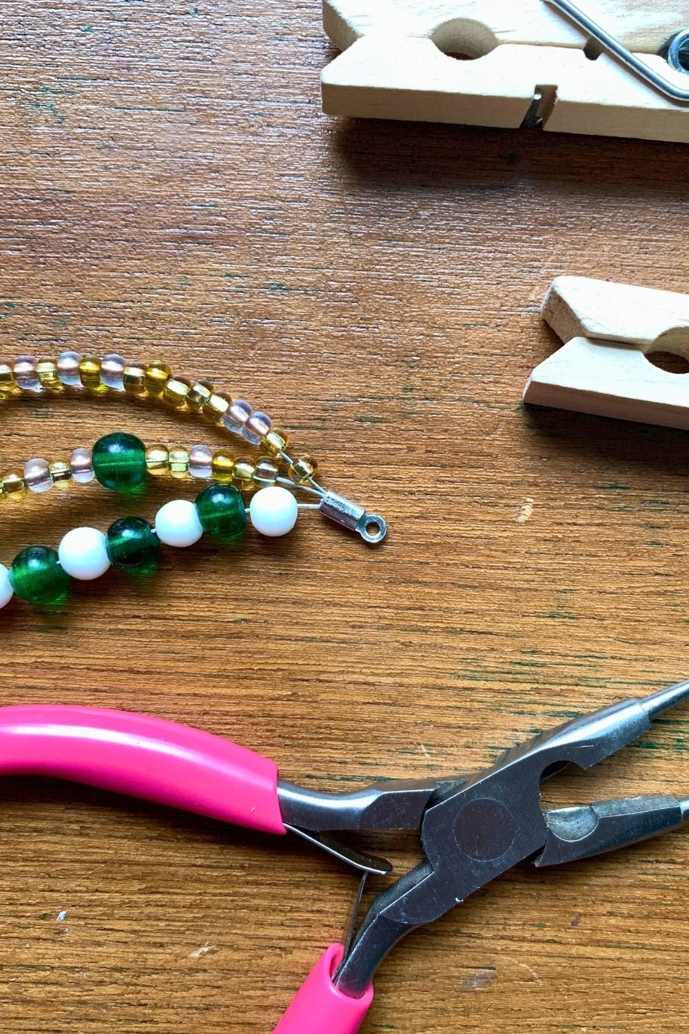Closing an end crimp over the finished end of a 3-strand bead bracelet.