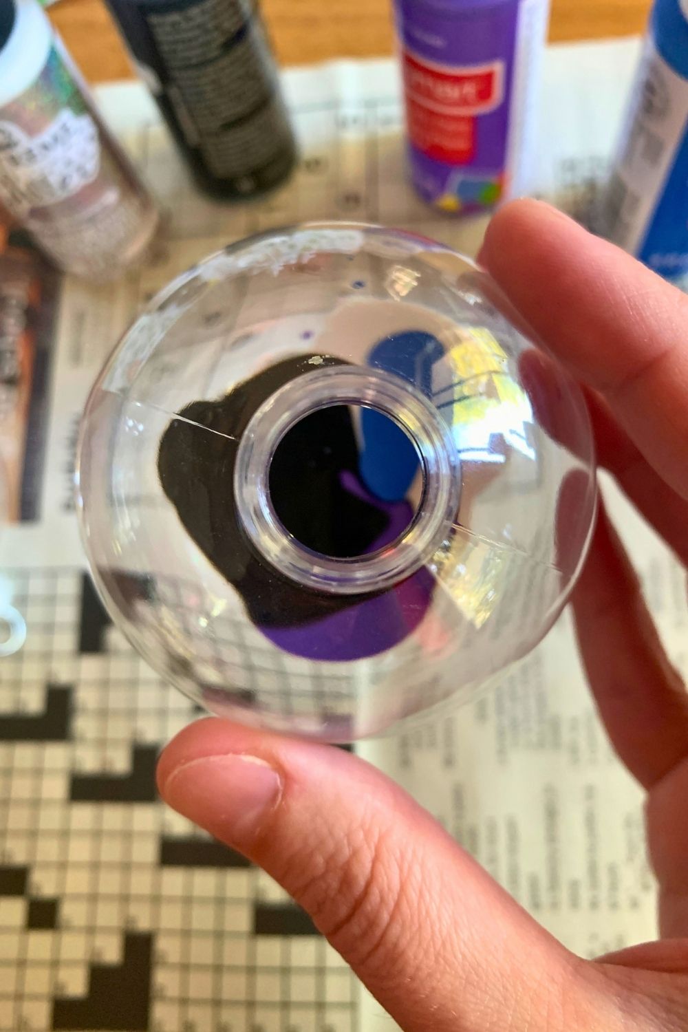 Small blobs of black, purple, and blue paint in a clear plastic ornament.