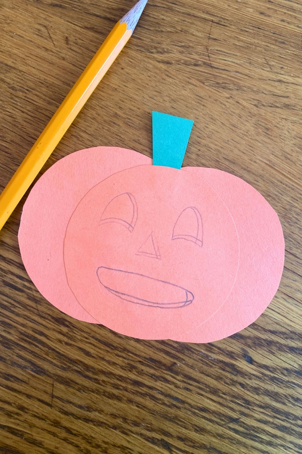 Pencil sketch of a jack-o'lantern face with rounded triangle eyes and nose, and a wide round mouth.