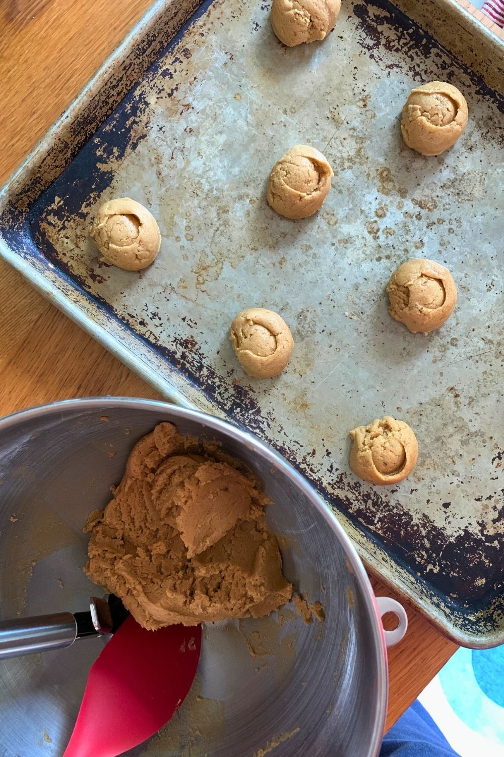 Rounded balls of peanut butter cookie dough on a metal baking sheet.