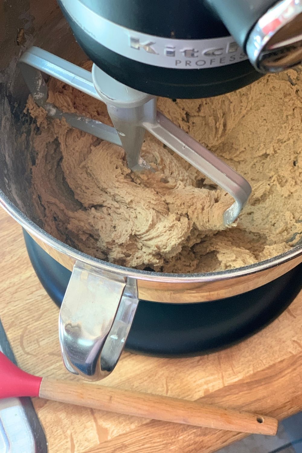 Adding flour and spices to cookie dough in a stand mixer.